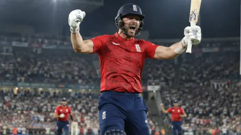 Editorial illustration of a generic England batter celebrating a floodlit T20 century before a roaring Southampton crowd